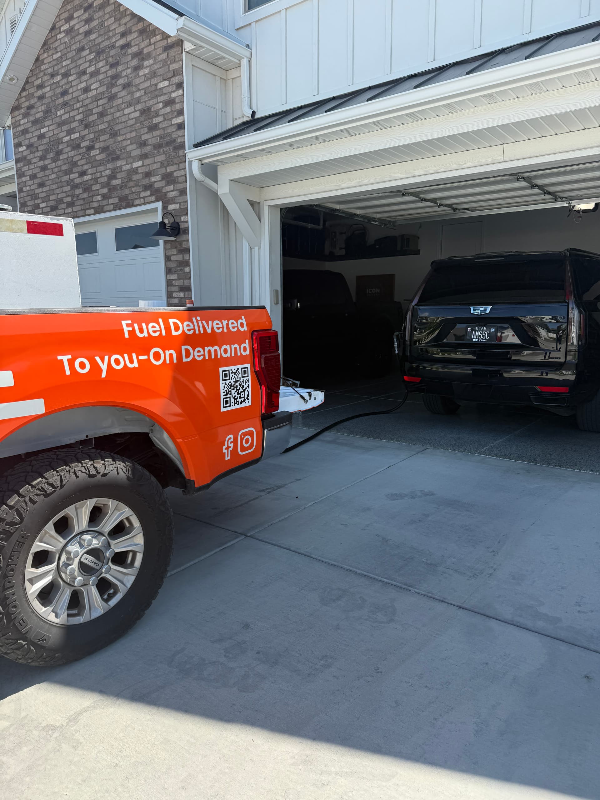Fuel delivery truck filling a car in a residential driveway
